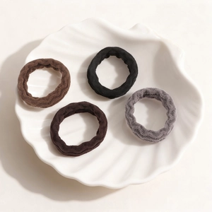 Set of four thick high-elastic plush hair ties in neutral colors on a decorative tray