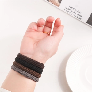 Elastic plush hair ties set in earth tones shown on wrist with a minimalist design