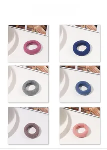 Detail shot of six thick high-elasticity hair ties in multiple colors on a white plate