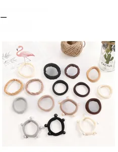 Detail view of earth-toned high elasticity hair ties with beads on a clean white backdrop
