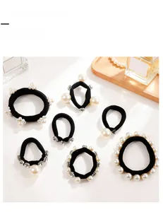 Dettaglio del set di 7 elastici per capelli con perle e strass su vassoio decorativo