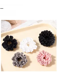 Detailed view of plush floral hair scrunchies set in five assorted soft winter colors