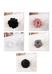 Detailed close-up of plush and textured scrunchies in black, pink, white, and grey colors