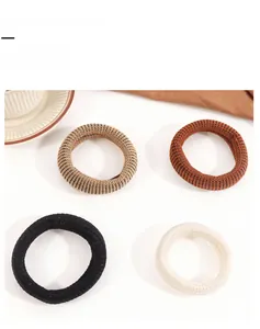 Detailed macro view of four elastic knit hair ties in earth-tone neutral colors