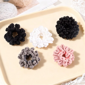 Plush velvet scrunchies in 5 colors on a beige tray for elegant hair styling