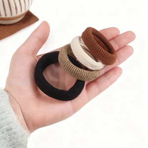 Set of four thick knitted hair ties in earth tones like black, brown, and khaki for ponytails
