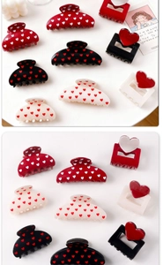 Close-up of heart pattern hair claws and clips in red, black, and white finishes