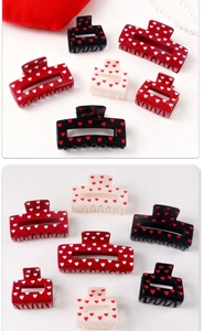 Detail of red, black, and white heart pattern hair claw clips in various sizes