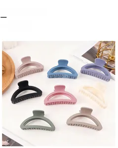 Detail view of eight matte hair claw clips in Morandi colors displayed on a wooden tray
