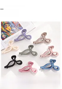 Vue à plat de huit grandes pinces à cheveux noeud mat dans diverses couleurs pastel