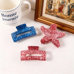 Three-piece hair claw clip set with starfish and floral textures in blue and red
