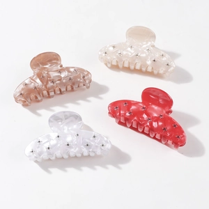 Set of four shell texture hair claws with rhinestones in cream, pink, white, and red