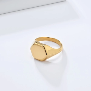 Macro shot of polished gold hexagonal signet ring with a smooth geometric flat top