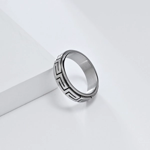 Détail de la bague rotative argentée ornée d'un motif de clé grecque méandre