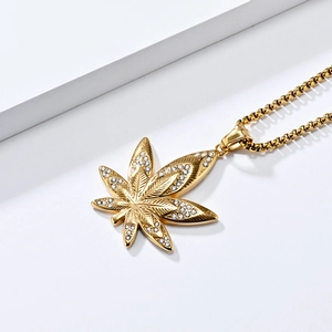 Détail macro du pendentif feuille d'érable plaqué or 18K serti de cristaux brillants