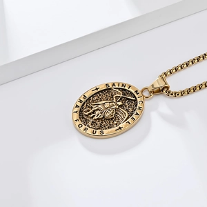 Detailed relief of Saint Michael fighting the dragon on a gold oval pendant necklace