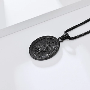 Close-up of Saint Michael pendant in matte black finish on minimalist white steps