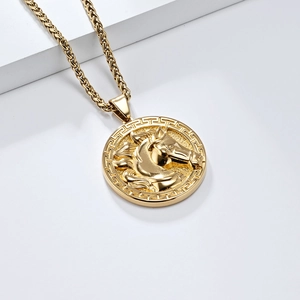 Detailansicht einer goldenen Kette mit Pferdekopf-Reliefanhänger auf einem Podest