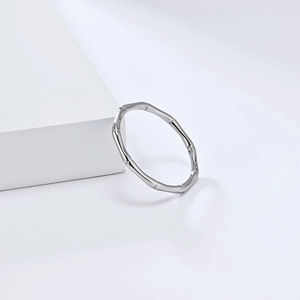 Detailopname van gepolijste zilveren bamboe ring op wit geometrisch platform