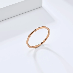 Detailopname van een elegante roségouden ring met bamboe structuur en gepolijste afwerking