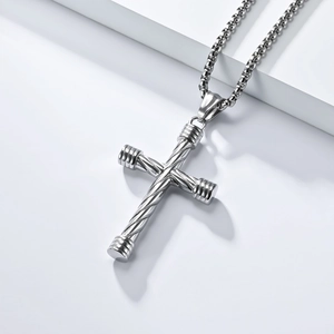 Detail of silver stainless steel cross pendant with spiral twisted texture on box chain