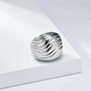 Detailed view of wide polished silver stainless steel dome ring with textured wavy finish