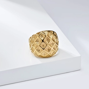 Detailed close-up of wide gold-plated stainless steel ring with textured lattice pattern