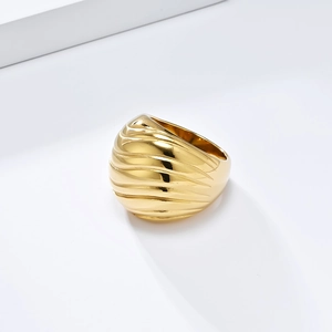 Bold chunky gold stainless steel ring with wave texture on elegant white geometric steps