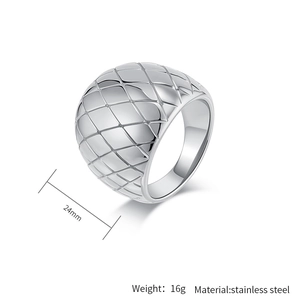 Macro detail of silver stainless steel dome ring with quilted grid texture pattern