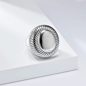 Detailed view of large silver ring with smooth oval surface and spiral metal textures