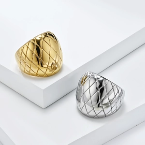 Polished gold and silver wide lattice textured rings on minimalist display