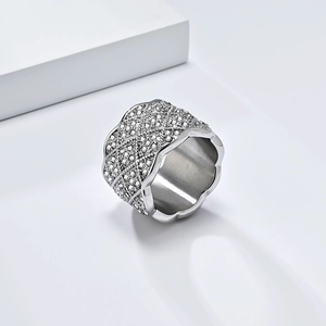 Gros plan sur une bague large argentée avec strass pavés et bords ondulés