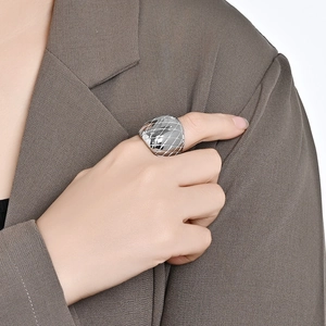 Polished silver wide band ring with quilted pattern on hand, modern steel jewelry