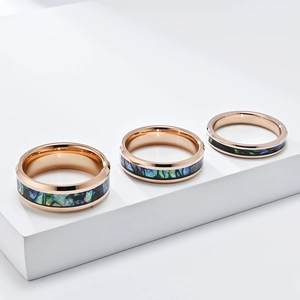 Detailed comparison of three rose gold tungsten rings with colorful abalone shell inlays