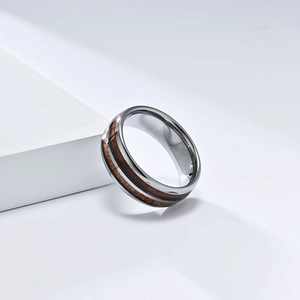 Detailed view of tungsten ring featuring dual wood grain inlays and polished metal finish