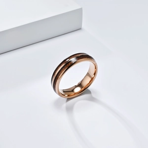 Detail of rose gold tungsten ring featuring double wood grain inlay and polished finish
