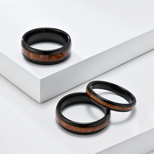 Poliertes schwarzes Wolfram-Ring-Set mit dunkler Holzeinlage auf weißen Ständern