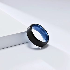 Detailsicht eines mattschwarzen Edelstahlrings mit einer leuchtend blauen Innenseite