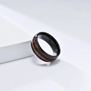 Detail view of black tungsten ring featuring dual walnut wood inlays on white geometric steps