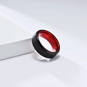 Minimalistischer Ring aus schwarzem Titan mit roter Innenseite auf weißem Grund