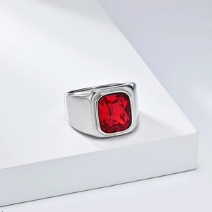 Détail d'une bague masculine en acier inoxydable avec une grande pierre rouge rectangulaire