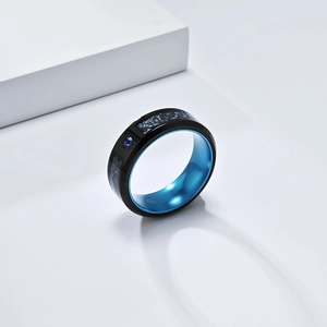 Macro shot of men's black titanium ring with blue dragon inlay and polished finish