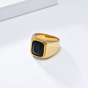 Détail d'une bague pour homme en acier doré avec une grande pierre précieuse noire