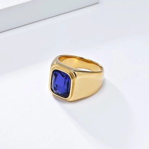Détail d'une bague en acier inoxydable doré avec une pierre rectangulaire bleu profond