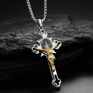 Detail of silver stainless steel cross necklace featuring a gold Jesus crucifix on stone