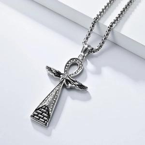 Macro detail of silver Ankh cross necklace with winged pyramid and white zircon stones