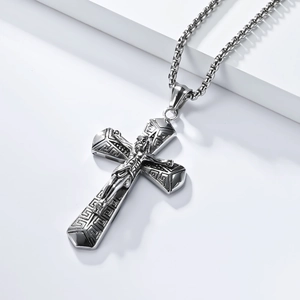 Macro shot of silver titanium steel crucifix necklace with ornate geometric engravings