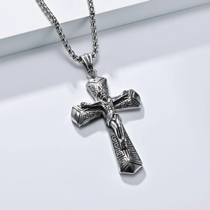Macro shot of silver retro cross pendant with Greek key pattern and Jesus crucifix detail