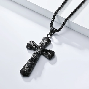 Macro shot of black titanium steel cross necklace with Jesus relief and geometric engraving