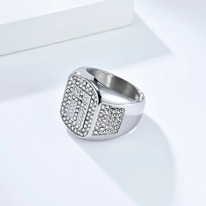 Macro view of silver hip hop ring with iced out rhinestones and a polished cross